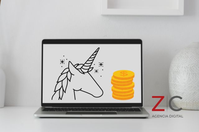 Computadora con unicornio representando startups y monedas / cortesía Canva