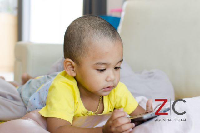 Niño viendo Facebook en celular / cortesía Canva